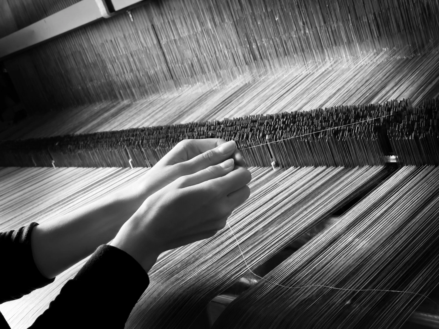 Mani al lavoro su un telaio piano Beltrami