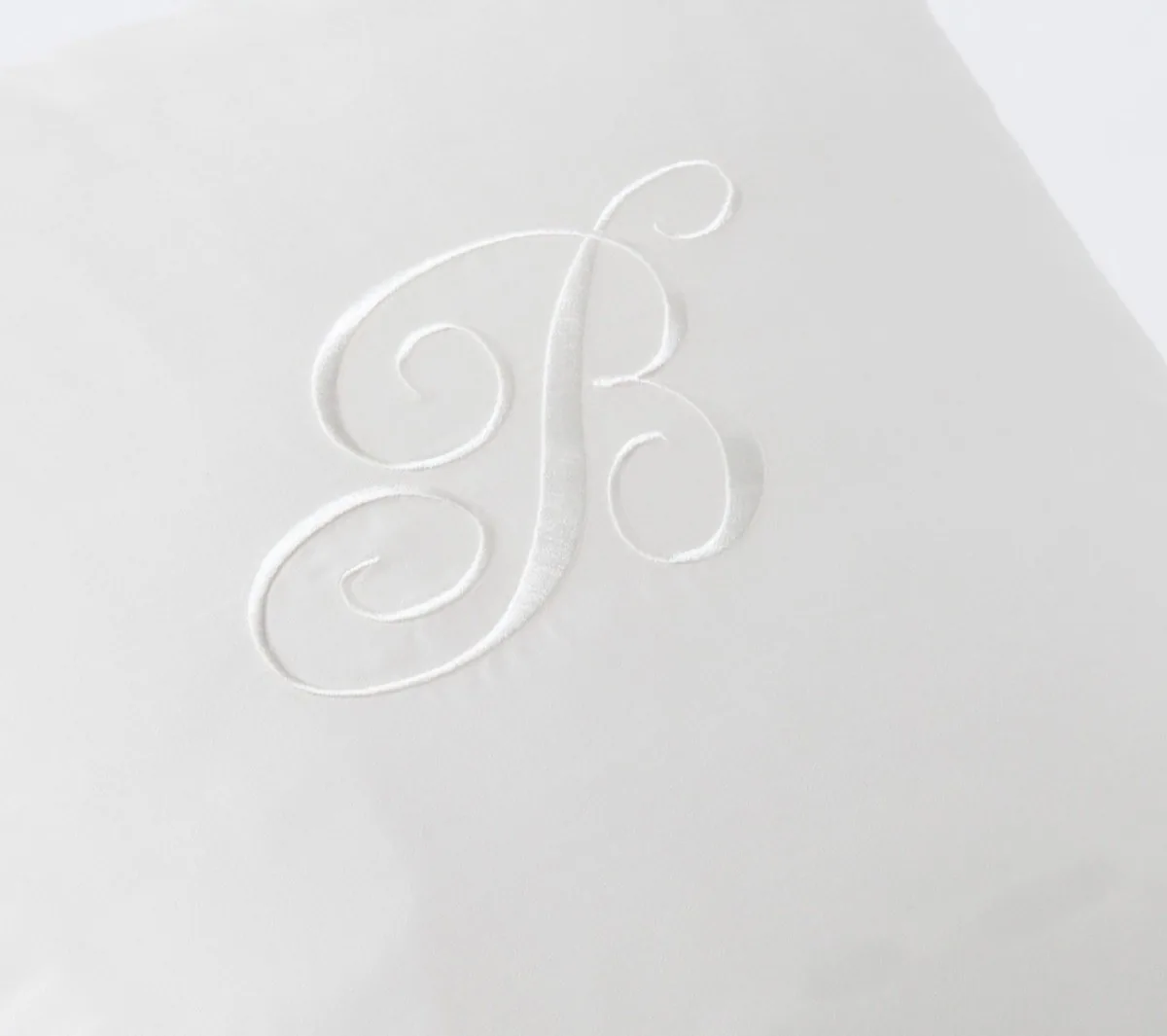 White-on-white cursive B monogram embroidered on satin
