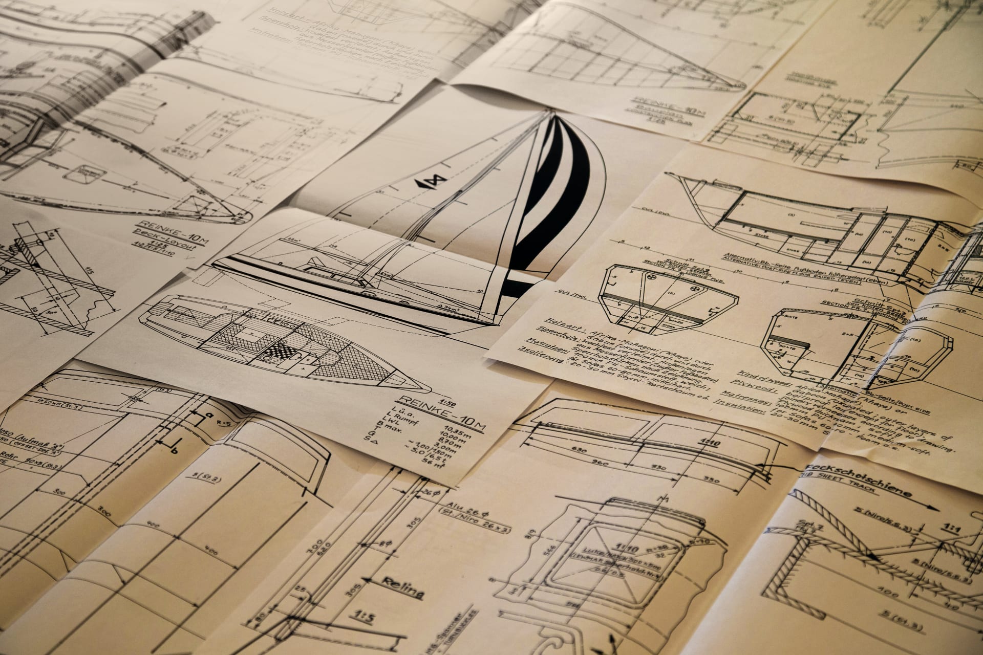Disegni di progetto e piani navali di uno yacht distesi su un tavolo