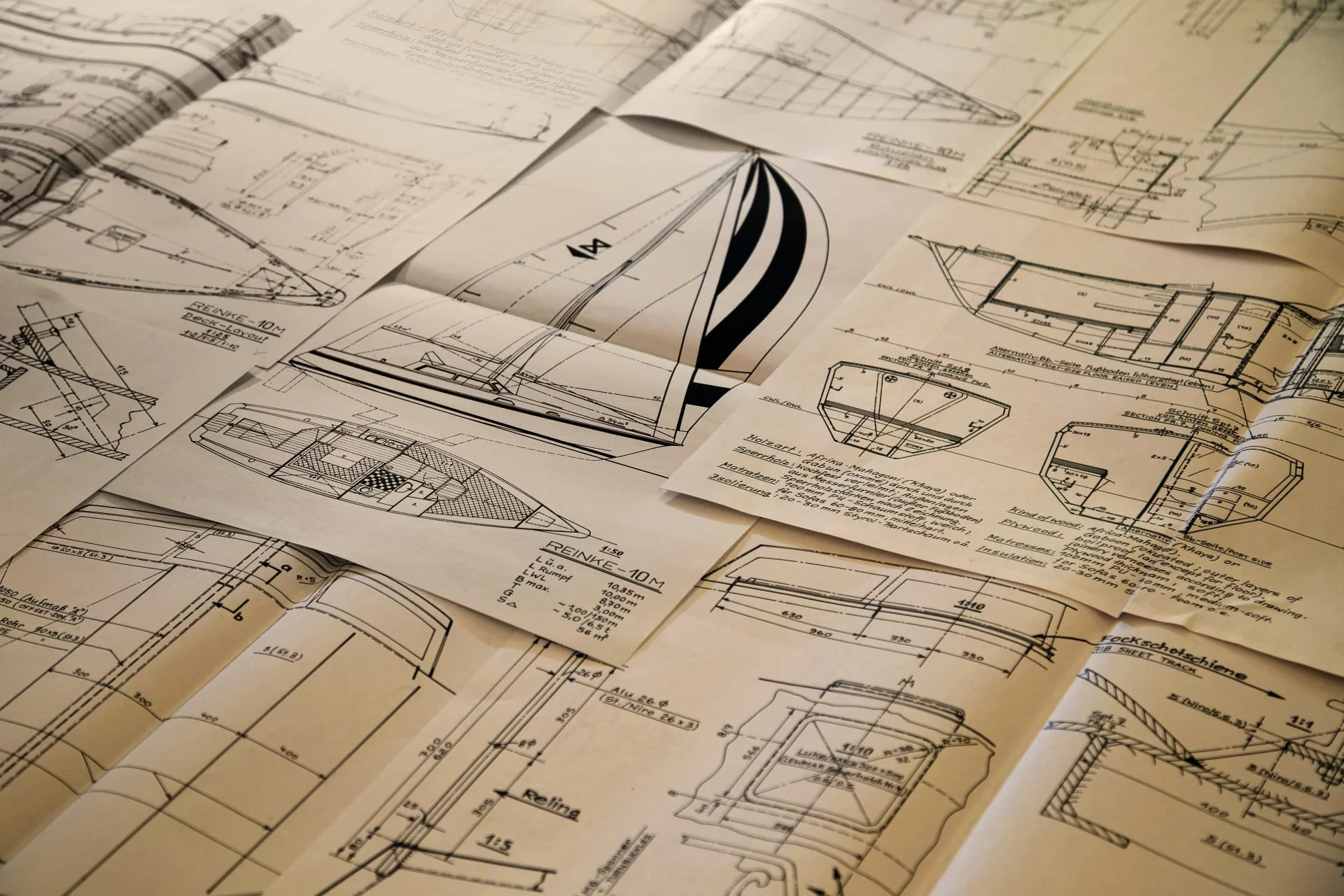 Yacht design drawings and naval plans spread across a table
